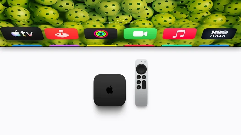 Apple TV 4K box beside its gray Siri Remote under a TV screen strip showing streaming app icons