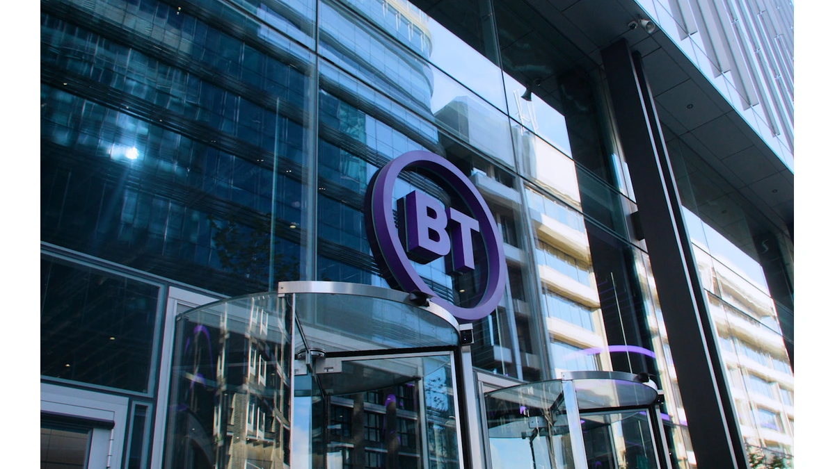 Glass office tower entrance with a purple round BT logo sign above the revolving doors