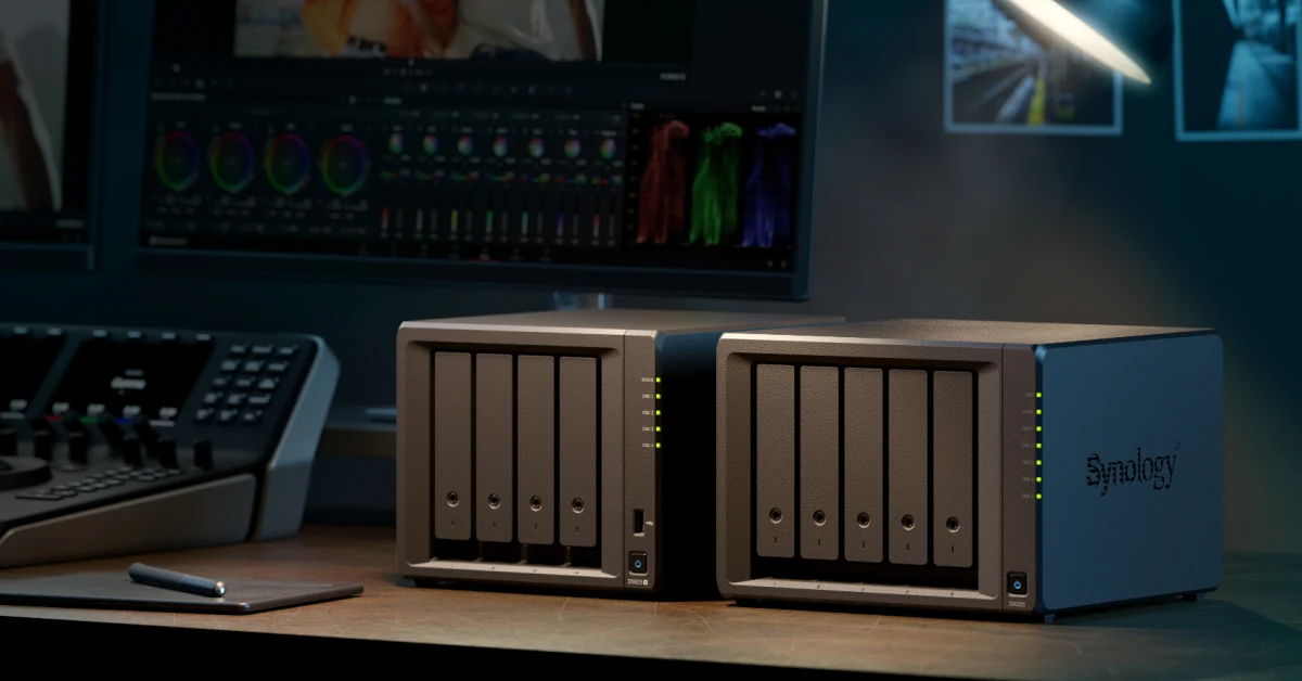 Synology DS925+ NAS beside a second NAS on a desk shows a video-editing setup with a monitor above