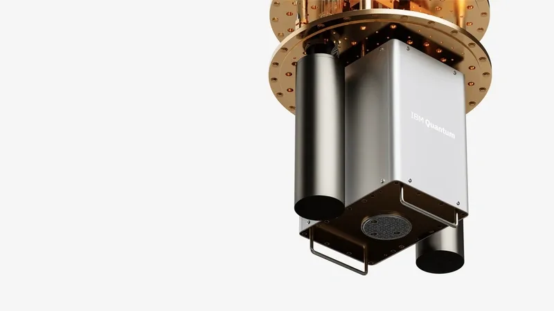 IBM Quantum hardware: a gold-plated circular stage above a silver enclosure marked IBM Quantum, on a pale gray backdrop