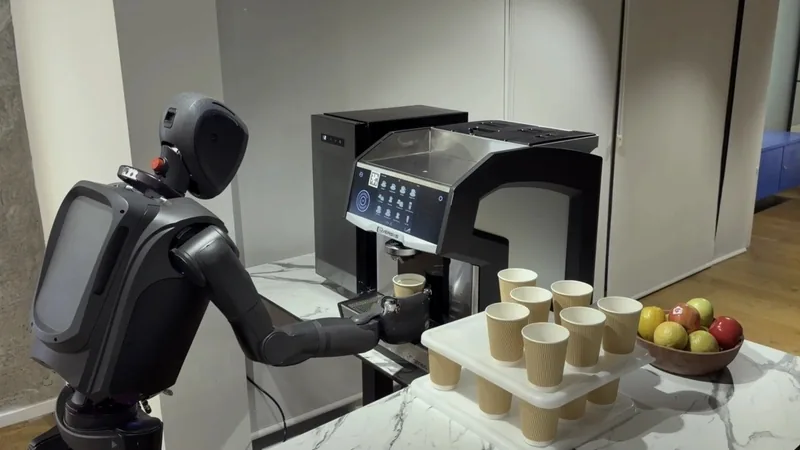 MenteeBot humanoid robot at a coffee machine beside rows of paper cups and a fruit bowl