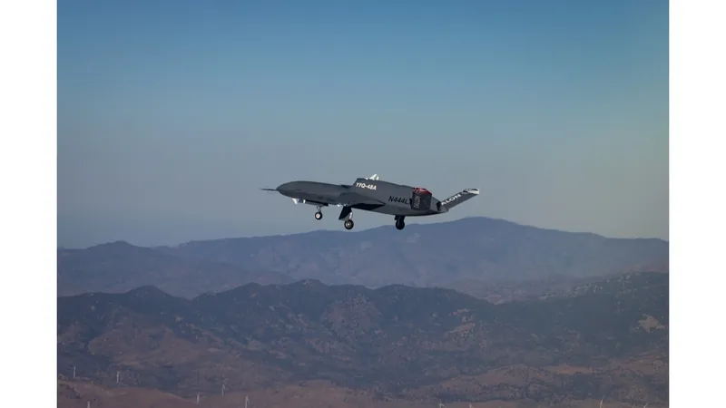 Northrop Grumman YFQ-48A Talon Blue in flight with its landing gear down over a mountain range