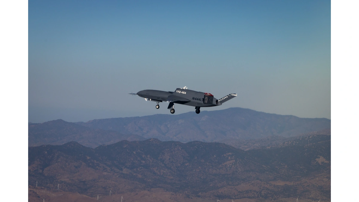 Northrop Grumman YFQ-48A Talon Blue in flight with its landing gear down over a mountain range
