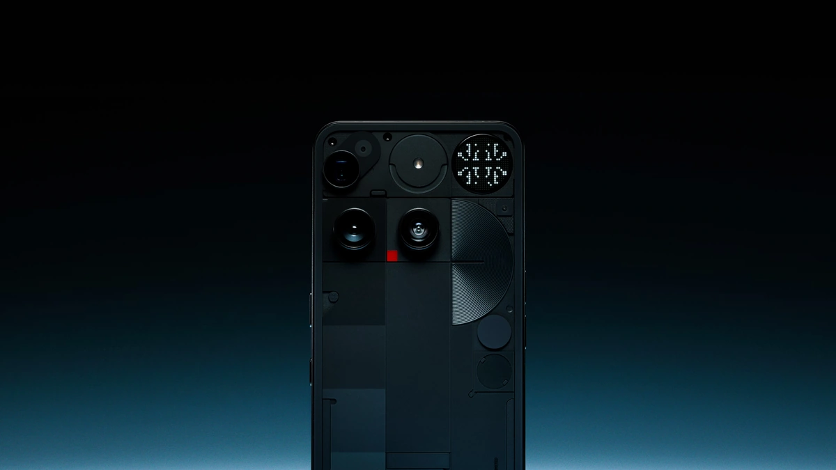 Nothing Phone (3) seen from the back, its transparent panel, three cameras and red recording light against a dark background