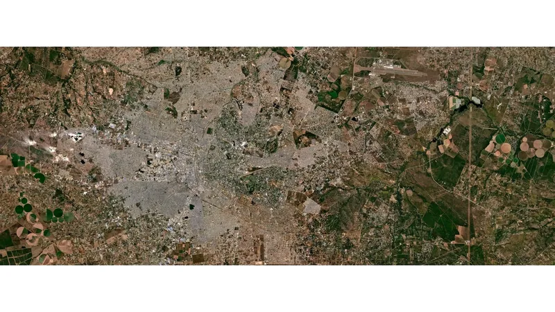 Planet Populace satellite view of a dense city spreading into surrounding farmland