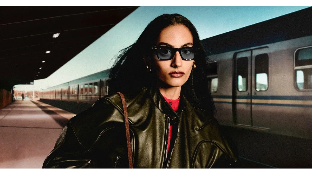 Ray-Ban Meta Audio glasses with dark lenses worn by a woman in a leather jacket on a train platform