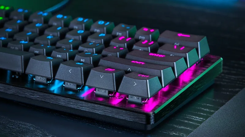 Razer Huntsman V3 Pro Mini keyboard with pink and blue backlit keys shown at an angle on a dark desk