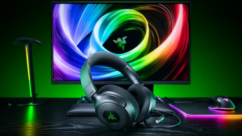 Razer Kraken V4 X headset on a desk in front of a monitor with swirling RGB wallpaper