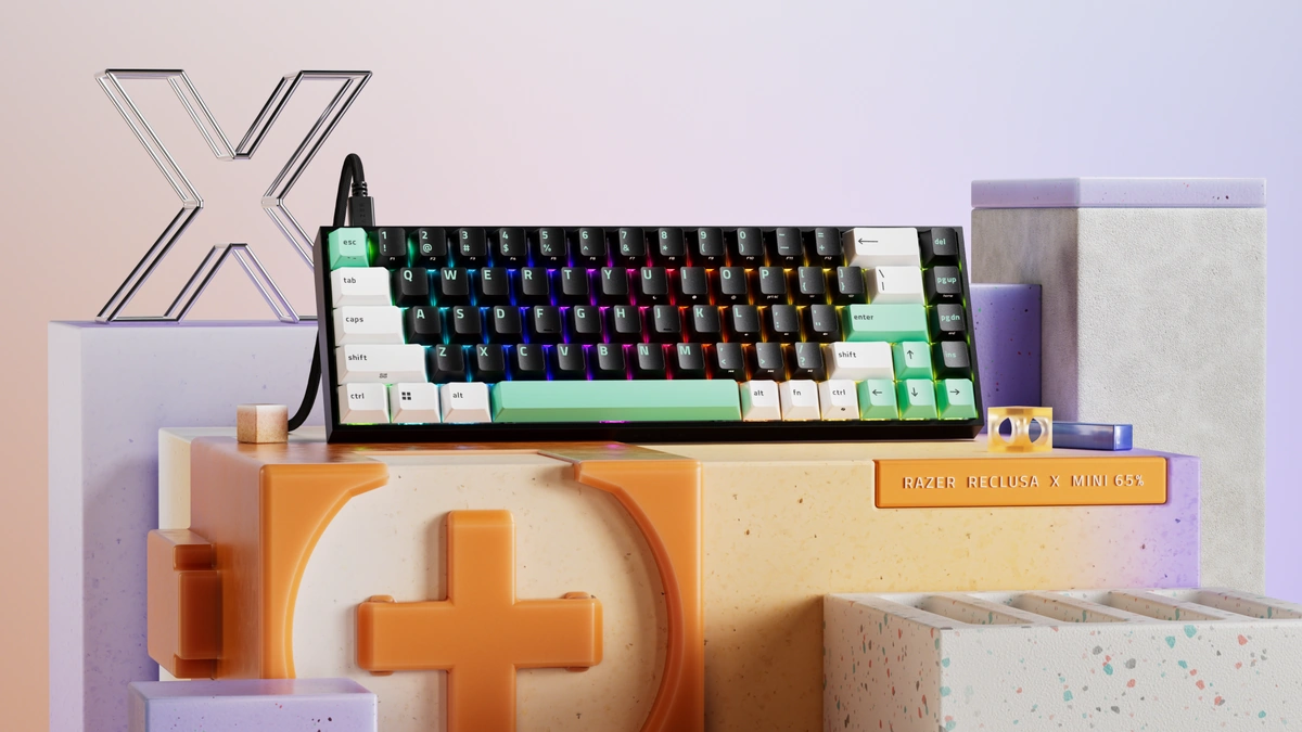 Razer Reclusa X Mini 65% keyboard with black, white and mint keycaps and rainbow backlighting on a pastel set