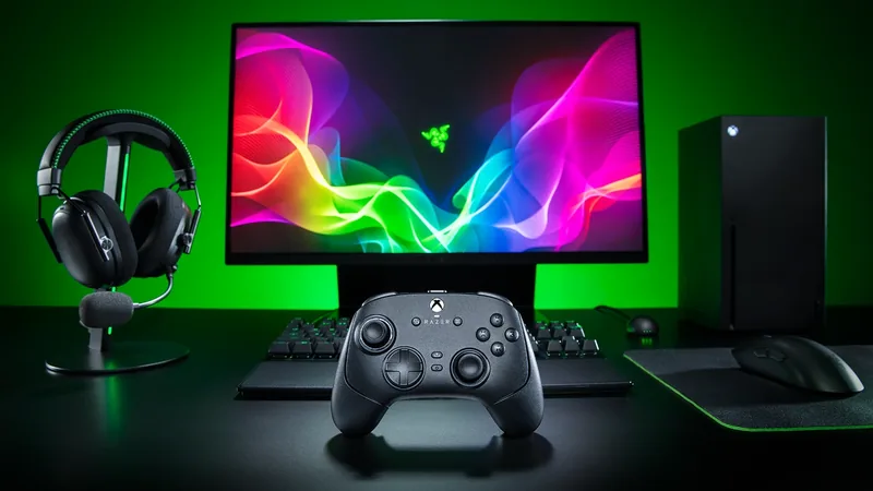 Razer Wolverine V4 controller in front of a green-lit gaming setup with a monitor and headset