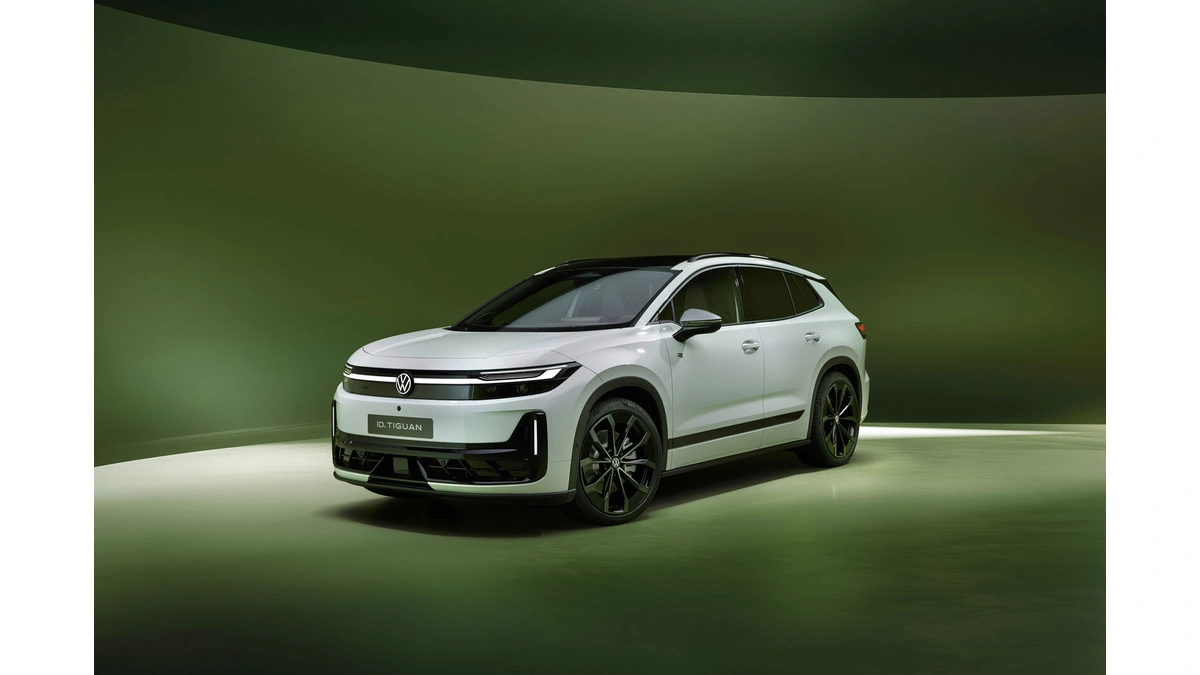 White Volkswagen ID. Tiguan electric SUV with black wheels in a green-lit studio